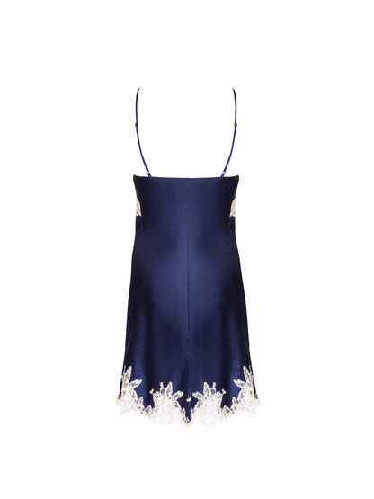 A navy satin slip dress with light lace trim is displayed from the back against a white background.