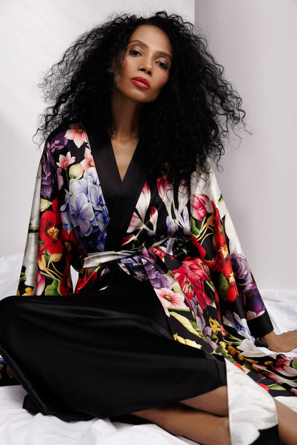Woman wearing a colorful floral silk kimono over full length nightgown, sold separately. Front picture in sitting position. 